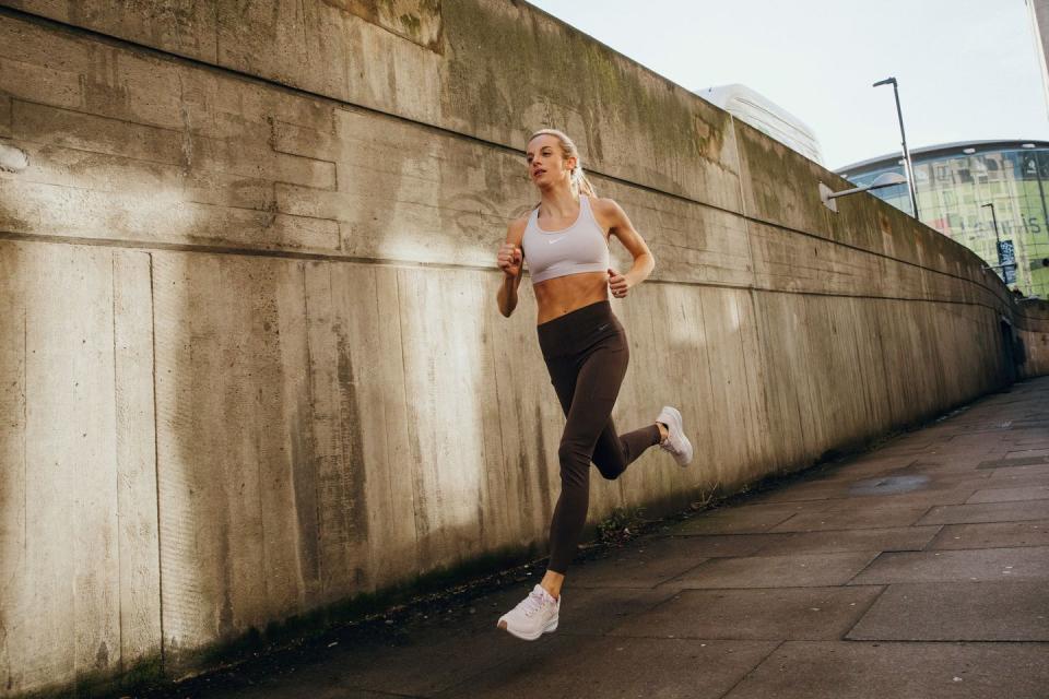 a woman running on a sidewalk