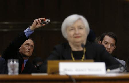 A member of the audience takes a picture as Janet Yellen, President Barack Obama's nominee to lead the U.S. Federal Reserve, prepares to testify at her U.S. Senate Banking Committee confirmation hearing in Washington, November 14, 2013. REUTERS/Jason Reed