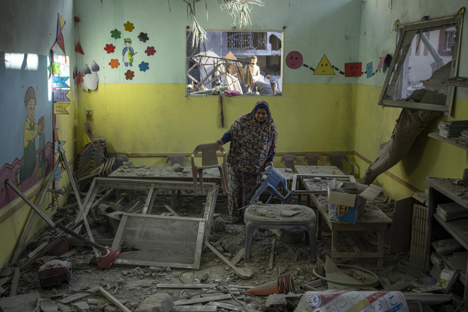 Palestinian woman cleans up after an Israeli strike on her neighborhood in Rafah, Gaza Strip, on Saturday, Dec. 9, 2023. (AP Photo/Fatima Shbair)