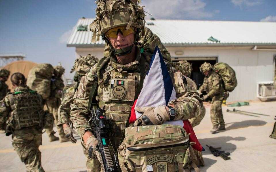 Wing Commander Matt Radnall, Officer Commanding 7 Force Protection Wing, folds the Union flag, which flew above Task Force Belleau Wood during the Final Operation HERRICK, - Ben Birchall/PA Wire