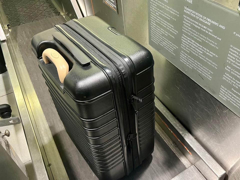 My black Beis carry-on bag with a beige handle.