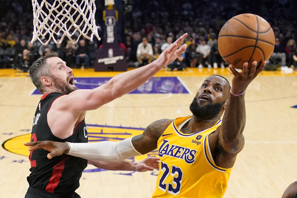 Los Angeles Lakers forward LeBron James, right, shoots as Miami Heat forward Kevin Love defends during the second half of an NBA basketball game Wednesday, Jan. 3, 2024, in Los Angeles. (AP Photo/Mark J. Terrill)