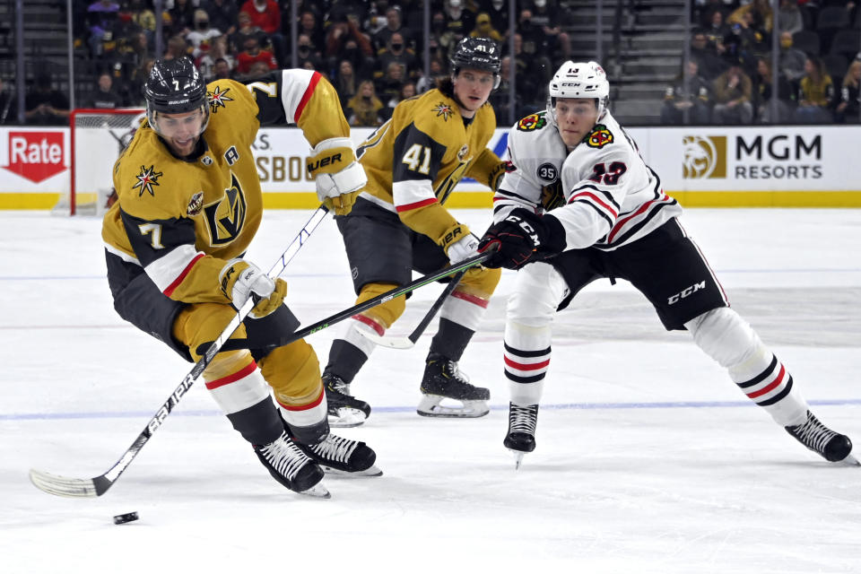 Vegas Golden Knights defenseman Alex Pietrangelo (7) skates with the puck next to Chicago Blackhawks center Henrik Borgstrom (13) during the first period of an NHL hockey game Saturday, Jan. 8, 2022, in Las Vegas. (AP Photo/David Becker)