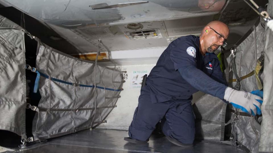 American Airlines cargo handler inside an airplane dealing with cargo.