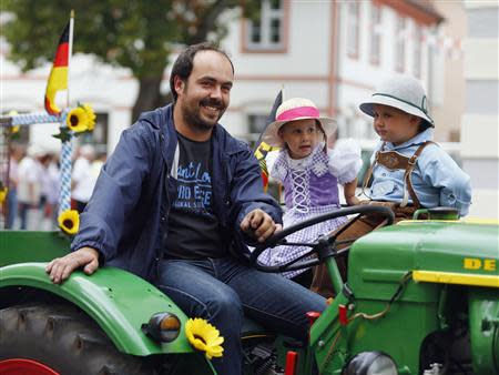 A man smiles as he drives his tractor during a Sunday Parade in Eichstaett September 8, 2013. REUTERS/Michael Dalder