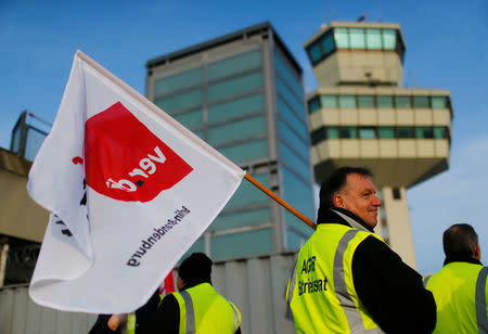 Members of Germany's Verdi union protest with flags at a gate at Tegel airport during a warning strike by ground services, security inspection and check-in staff in Berlin, Germany March 13, 2017. REUTERS/Hannibal Hanschke