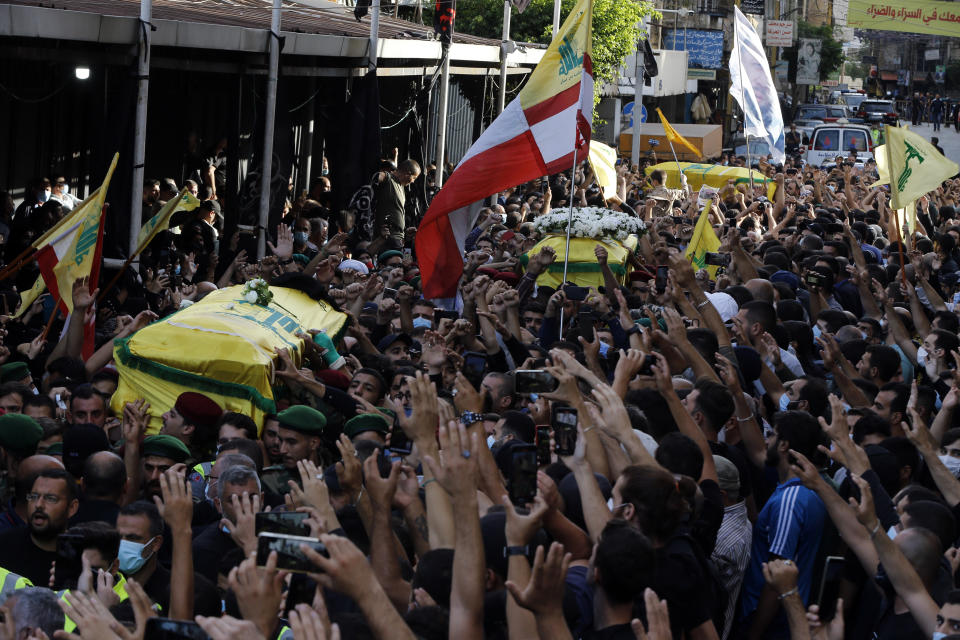 FILE - In this Oct. 15, 2021 file photo, mourners carry the coffins of three Hezbollah supporters who were killed during Thursday clashes, during their funeral processions in the southern Beirut suburb of Dahiyeh, Lebanon. The shootout on the streets of Beirut between rival Christian and Muslim groups has revived memories of the country's 1975-90 civil war and fired up sectarian passions in a country that never dealt with the causes of its violent past. (AP Photo/Bilal Hussein, File)