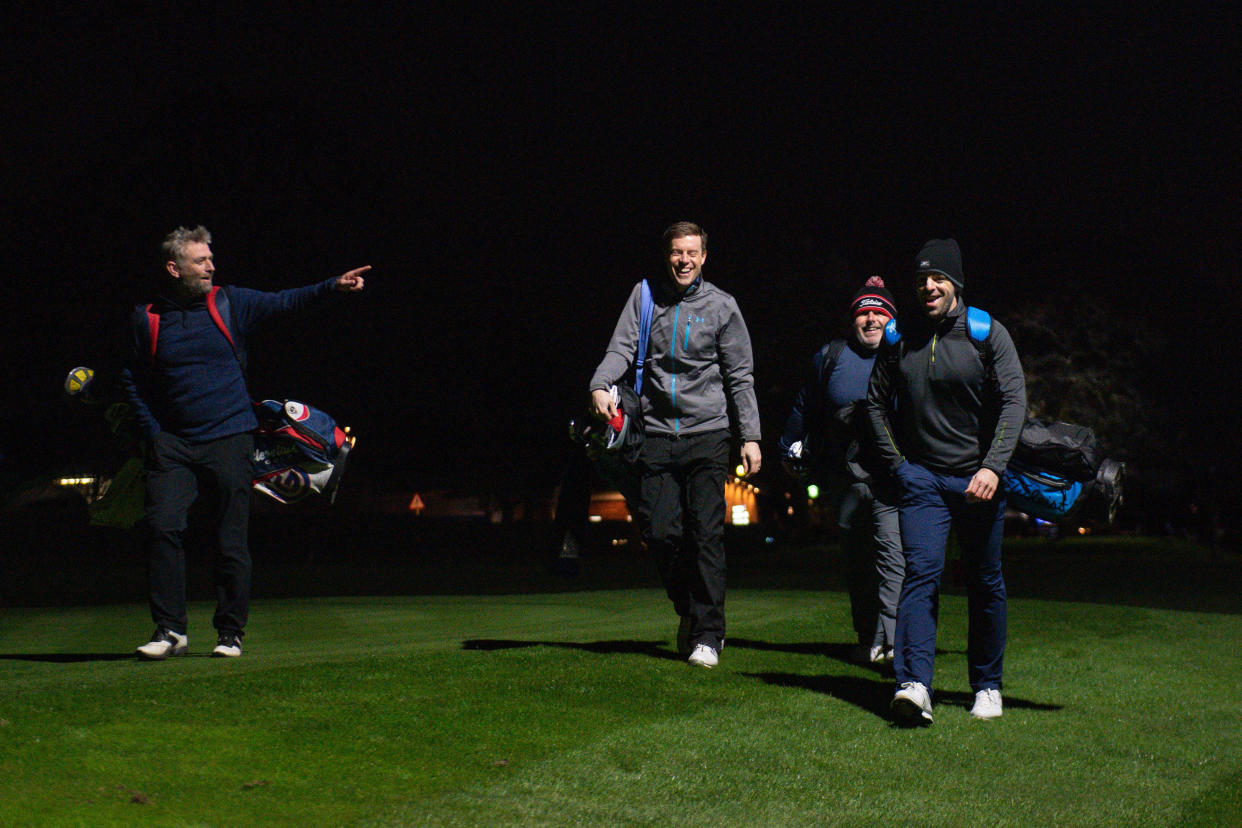 A group of golfers under floodlights at Morley Hayes Golf centre in Ilkeston, Derbyshire. The club is believed to be the first to reopen, with the first tee times at 0001, following the easing of England's lockdown restrictions to allow greater freedom outdoors. Picture date: Monday March 29, 2021.