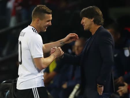 Football Soccer - Germany v England - International Friendly - Signal-Iduna-Park, Dortmund, Germany - 22/3/17 Germany's Lukas Podolski shakes hands with coach Joachim Low as he walks off to be substituted Reuters / Wolfgang Rattay Livepic