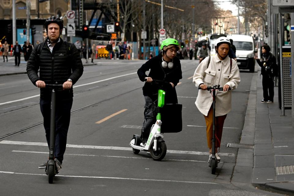 People ride electric scooters through Melbourne's central business district on August 14, 2024 (AFP via Getty)