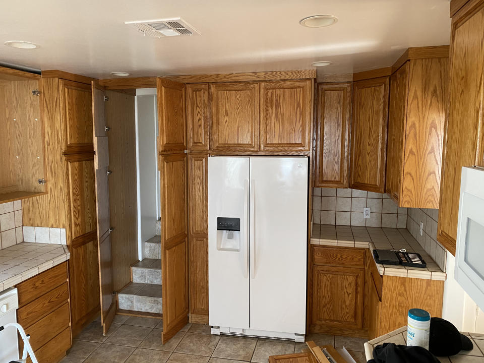 A dated kitchen with wooden cabinetry