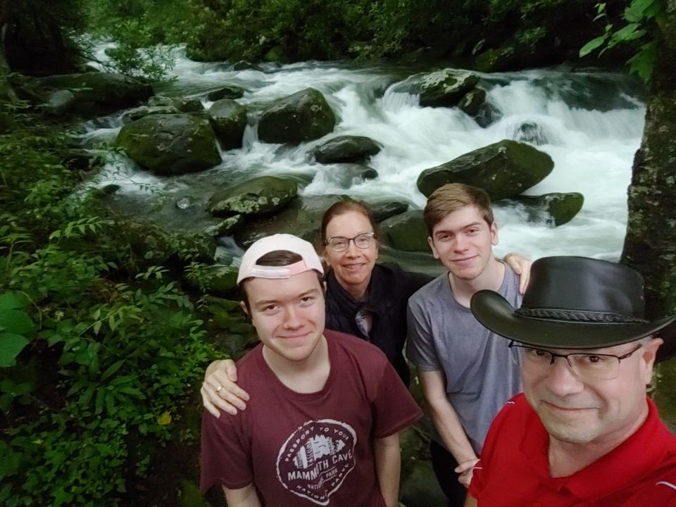 The Johnson family pose for a selfie near a rushing river.