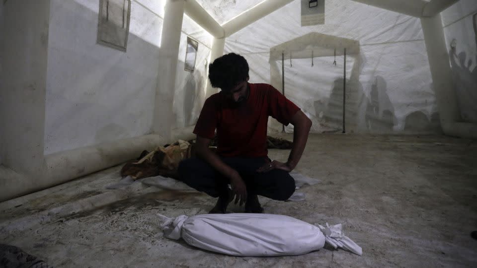 A Palestinian man mourns next to the body of his child, who was killed in Israeli airstrikes, at al-Shifa hospital, in Gaza City, on October 24. Israel's bombardment has killed more children in Gaza in the past three weeks than during armed conflict worldwide each year since 2019, according to Save the Children. - Abed Khaled/AP