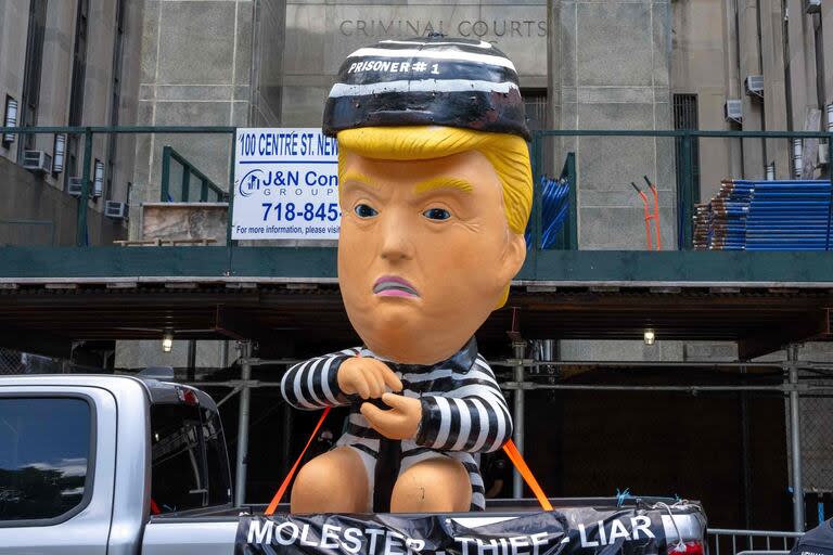 Una persona pasa por el Tribunal Penal de Manhattan con un globo inflable que representa al ex presidente estadounidense Donald Trump con uniforme carcelario el 28 de mayo de 2024 en la ciudad de Nueva York.