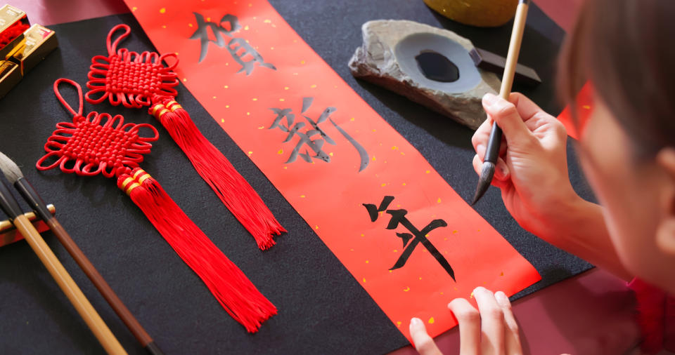 Close up of writing spring festival couplets to celebrate Chinese holidays with word meaning new year