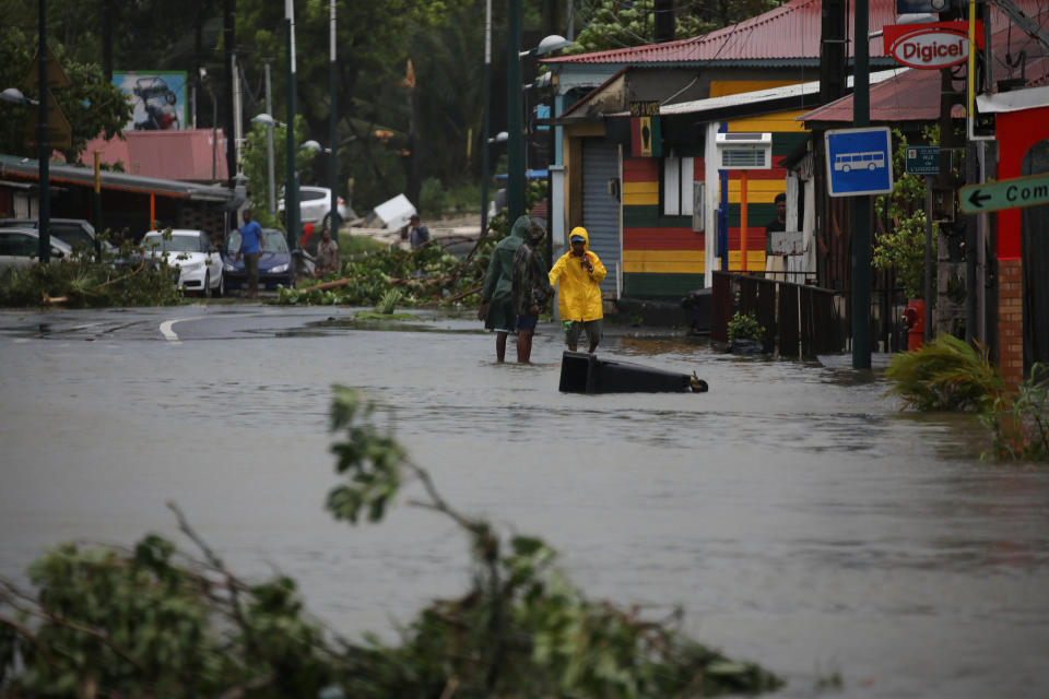 People walk in a flooded street in Pointe-a-Pitre, Guadeloupe, on Sept. 19, 2017.