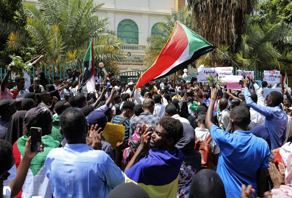Sudanese protesters wave national flags outside the Cabinet’s headquarters in the capital, Khartoum, Sudan, Monday, Aug. 17, 2020. The protesters returned to the streets Monday to pressure transitional authorities for more reforms, a year after a power-sharing deal between the pro-democracy movement and the generals. (AP Photo/Marwan Ali)