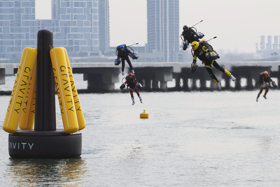 Jet suit pilots race in Dubai, United Arab Emirates, Wednesday, Feb. 28, 2024. Dubai on Wednesday hosted what it called its first-ever jet suit race. Racers zipped along a route with the skyscrapers of Dubai Marina looming behind them, controlling the jet engines on their hands and their backs. (AP Photo/Jon Gambrell)