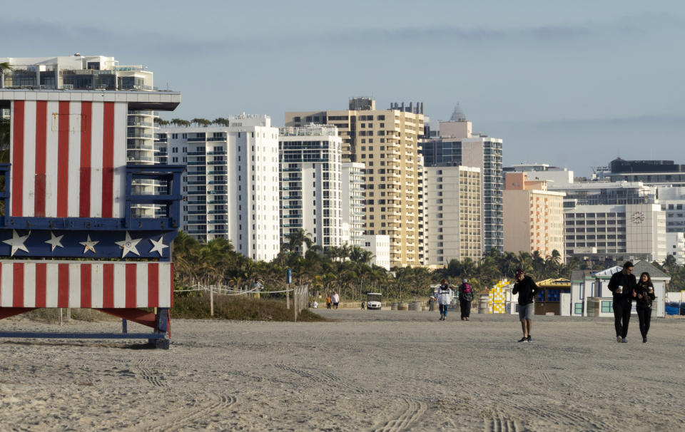 In this photo taken on Jan. 21, 2019, people walk past a lifeguard booth painted in the colors of an American flag on a beach in Miami Beach, Fla. The Miami area is popular among Russians not only for its tropical weather but also because of the large Russian-speaking population. Sunny Isles Beach, a city just north of Miami, is even nicknamed “Little Moscow”. (AP Photo/Iuliia Stashevska)