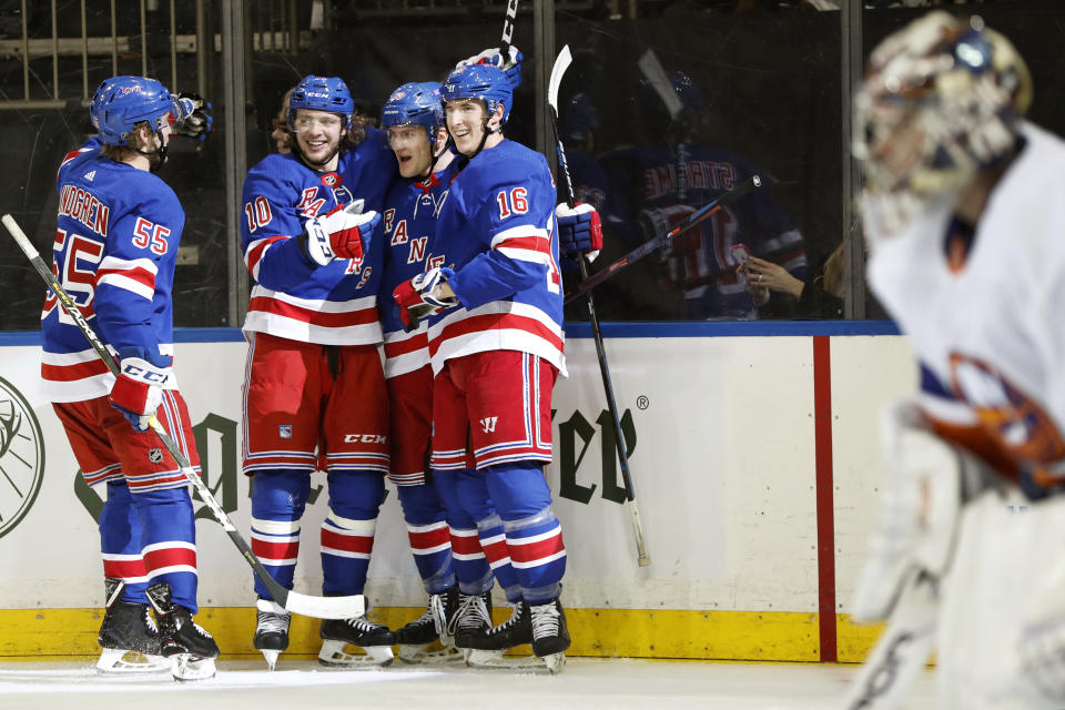 New York Rangers defenseman Ryan Lindgren (55) skates up to Rangers left wing Artemi Panarin (10), Rangers defenseman Adam Fox (23) and Rangers center Ryan Strome (16) after Fox scored against New York Islanders goaltender Semyon Varlamov, right, during the second period of an NHL hockey game, Monday, Jan. 13, 2020, in New York. (AP Photo/Kathy Willens)