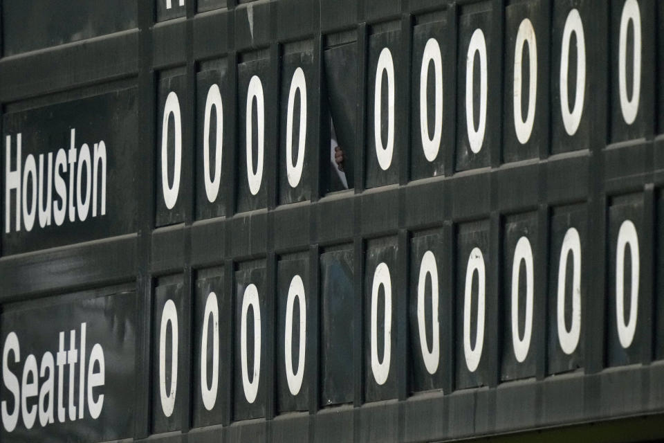 A worker changes the scoreboard in a scoreless game during the 15th inning in Game 3 of an American League Division Series baseball game between the Seattle Mariners and the Houston Astros, Saturday, Oct. 15, 2022, in Seattle. (AP Photo/Stephen Brashear)