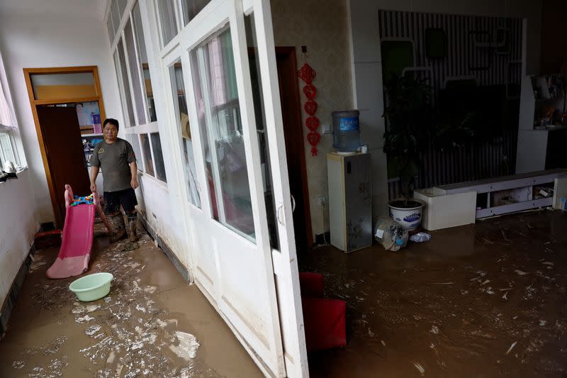 Wang Hui at his damaged home after rain and floods in Zhuozhou