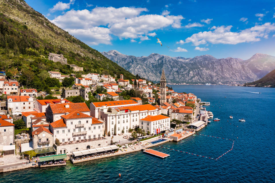 View of the historic town of Perast at famous Bay of Kotor on a beautiful sunny day with blue sky and clouds in summer, Montenegro. Historic city of Perast at Bay of Kotor in summer, Montenegro.