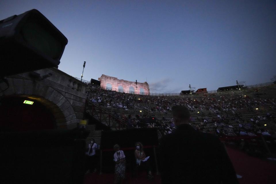 Spectators attend the 'Cavalleria Rusticana' lyric opera, at the Arena di Verona theatre, in Verona, Italy, Friday, June 25, 2021. The Verona Arena amphitheater returns to staging full operas for the first time since the pandemic struck but with one big difference. Gone are the monumental sets that project the scene to even nosebleed seats in the Roman-era amphitheater, replaced by huge LED screens with dynamic, 3D sets that are bringing new technological experiences to the opera world. (AP Photo/Luca Bruno)