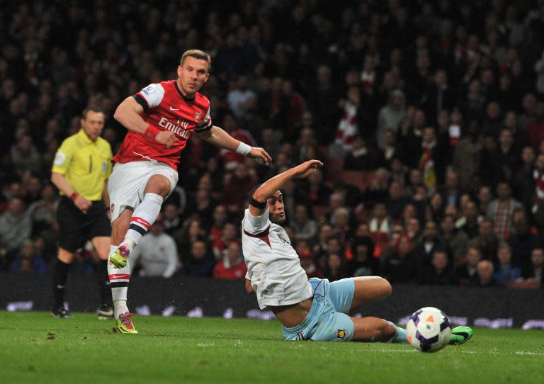 Arsenal's Polish-born German striker Lukas Podolski (L) shoots to score a goal during the English Premier League football match between Arsenal and West Ham United at the Emirates Stadium in London on April 15, 2014