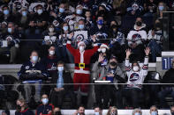 Winnipeg Jets fans cheer during the second period of NHL hockey game action against the St. Louis Blues in Winnipeg, Manitoba, Sunday, Dec. 19, 2021. (Fred Greenslade/The Canadian Press via AP)