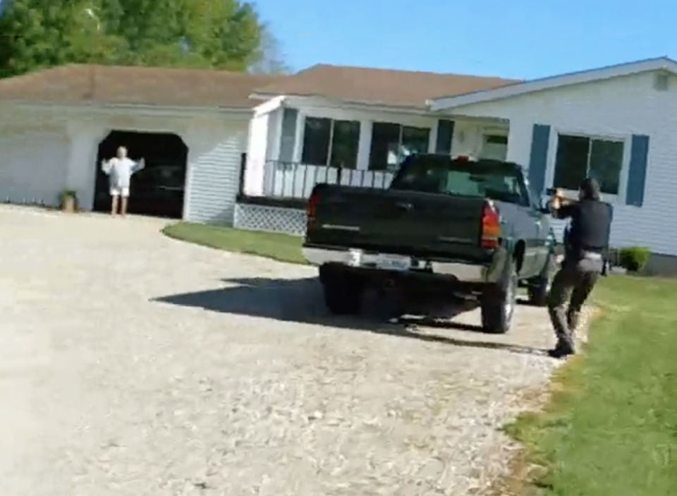 Cora Baughman steps out from the open garage of a home captured in this screenshot from footage of a camera worn by a Garrettsville police officer who responded with a sheriff's deputy in front of him to Werger Road on the morning of May 14.