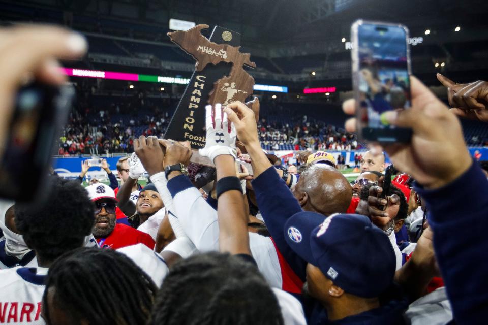 Southfield A&T players and coaches celebrate a 36-32 win over Belleville at Division 1 state final at Ford Field in Detroit on Sunday, Nov. 26, 2023.