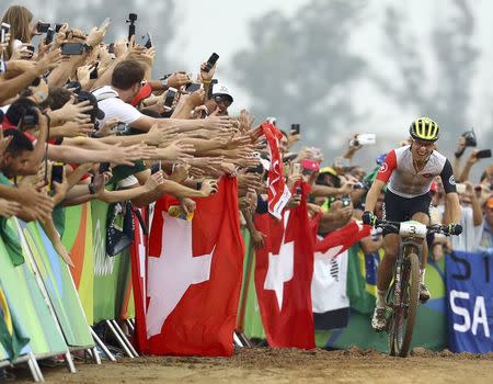 2016 Rio Olympics - Cycling mountain bike - Final - Men's Cross-country Race - Mountain Bike Centre - Rio de Janeiro, Brazil - 21/08/2016. Nino Schurter (SUI) of Switzerland celebrates before crossing the finish line. REUTERS/Paul Hanna