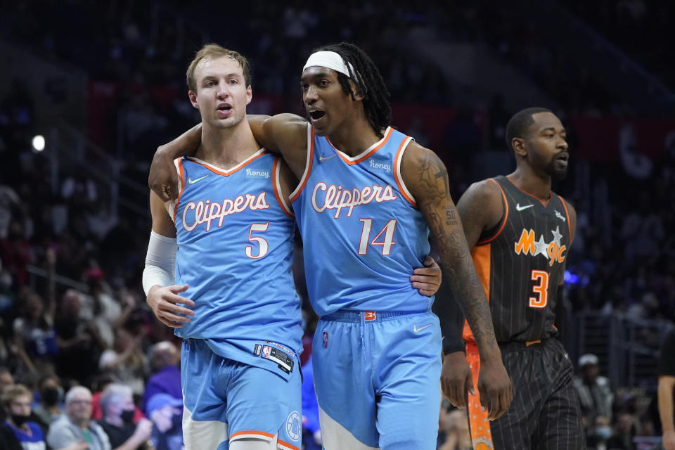 Los Angeles Clippers guard Luke Kennard (5) celebrates his 3-point basket with guard Terance Mann (14) during the second half of an NBA basketball game against the Orlando Magic Saturday, Dec. 11, 2021, in Los Angeles. (AP Photo/Marcio Jose Sanchez)