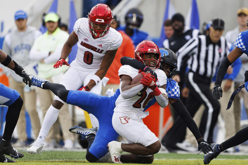 Kentucky defensive back Jordan Lovett (25) tackles Louisville running back Maurice Turner (20) during the first half of an NCAA college football game in Lexington, Ky., Saturday, Nov. 26, 2022. (AP Photo/Michael Clubb)