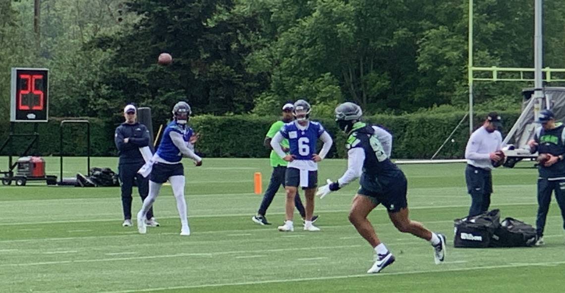 Seahawks quarterback Geno Smith throws while backup Sam Howell (6) watches the work with tight ends during the second of 10 NFL organized team activities (OTAs) practices at Seattle Virginia Mason Athletic Center in Renton May 22, 2024.