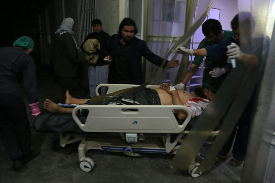 A man injured in a suicide bombing is brought into a hospital for treatment, in Kabul, Afghanistan, Nov. 20, 2018. Afghan officials said the suicide bomber targeted a gathering of Muslim religious scholars in Kabul, killing at least tens of people. A Public Health Ministry spokesman said another 60 people were wounded in the attack, which took place as Muslims around the world marked the birthday of the Prophet Mohammad. (AP Photo/Rahmat Gul)