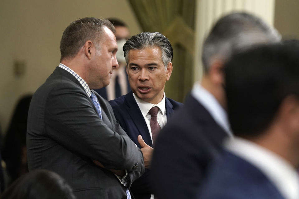California Attorney General Rob Bonta, right, talks with Assemblyman Adam Gray, D-Merced, as lawmakers discussed a gun control measure in the Assembly in Sacramento, Calif., Thursday, Sept. 1, 2022. Bonta was among working to get support for the bill, by state Sen. Anthony Portantino, to replace limits on carrying concealed weapons permits that were struck down by a recent U.S. Supreme Court ruling. Gray was among those who did not cast a vote and the measure fell short for the votes needed for passage.(AP Photo/Rich Pedroncelli)