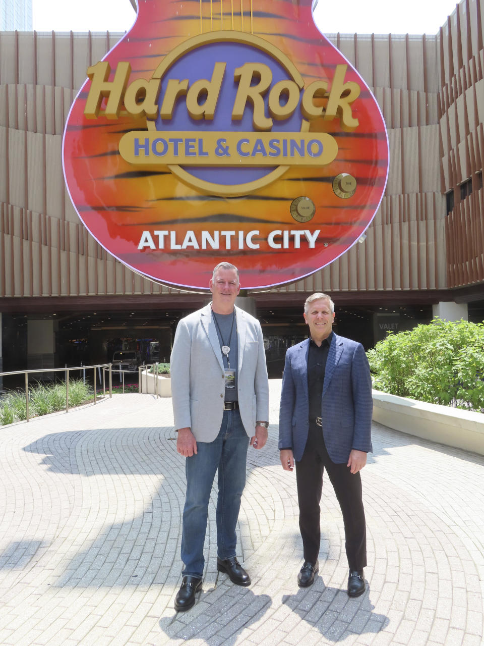 Mike Sampson, general manager of the Hard Rock casino, left, and George Goldhoff, president of the casino, right, pose in front of the casino's guitar statue in Atlantic City, N.J., on June 15, 2023. The city's two newest casinos - Hard Rock and Ocean - which both opened on June 27, 2018, have become the second and third most successful Atlantic City casinos in terms of money won from in-person gamblers. (AP Photo/Wayne Parry)