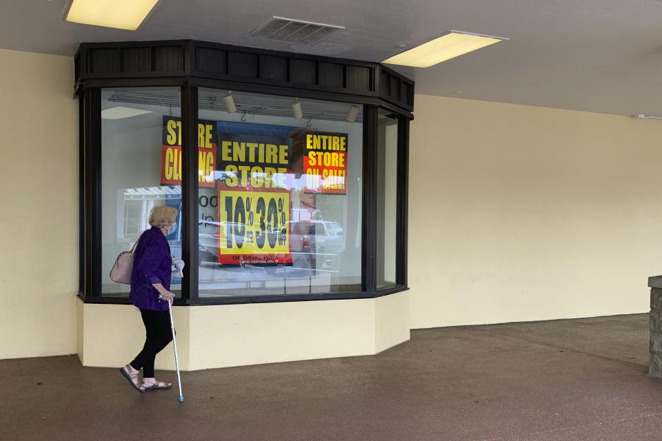 A woman walks in front of Stein Mart Wednesday, Aug 12, 2020 in St. Petersburg, Fla. The national discount department store chain is filing for bankruptcy and will close most, if not all, of its stores. The 112-year-old Florida-based company said in a news release that it filed for Chapter 11 protection on Wednesday. (AP Photo/Tamara Lush)