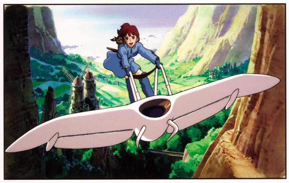 Nausicaa riding her glider through a canyon while her pet Teto sits on her shoulder