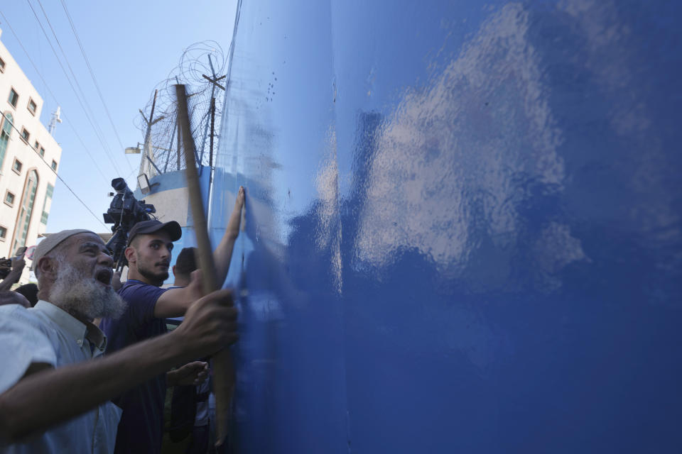 Palestinian demonstrators pound on gates of the United Nations Relief and Works Agency (UNRWA), demanding that the agency fulfil promises to compensate them for losses to their homes during the 2014 war, in Gaza City, Thursday, Sept. 7, 2023. The protest revealed public desperation amid ongoing efforts to alleviate Gaza's housing crisis, including an Egyptian-funded project that aims to complete 1,400 apartments by the end of this year. (AP Photo/Adel Hana)