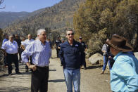 Nevada Gov. Steve Sisolak, front left, California Gov. Gavin Newsom, center, tour areas destroyed by wildfires near where the Tamarack Fire ignited earlier in July in Gardnerville, Nev., Wednesday, July 28, 2021. The governors of California and Nevada are calling for increased federal assistance as they tour an area blackened by one of several massive wildfires that have destroyed dozens of homes. Wednesday's tour of the Tamarack Fire along the state line comes as numerous wildfires char land and homes in a dozen states. (AP Photo/Sam Metz)