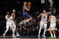 New York Knicks guard Evan Fournier (13) looks to pass in front of Denver Nuggets center Nikola Jokic during the first half of an NBA basketball game Saturday, Dec. 4, 2021, in New York. (AP Photo/Adam Hunger)