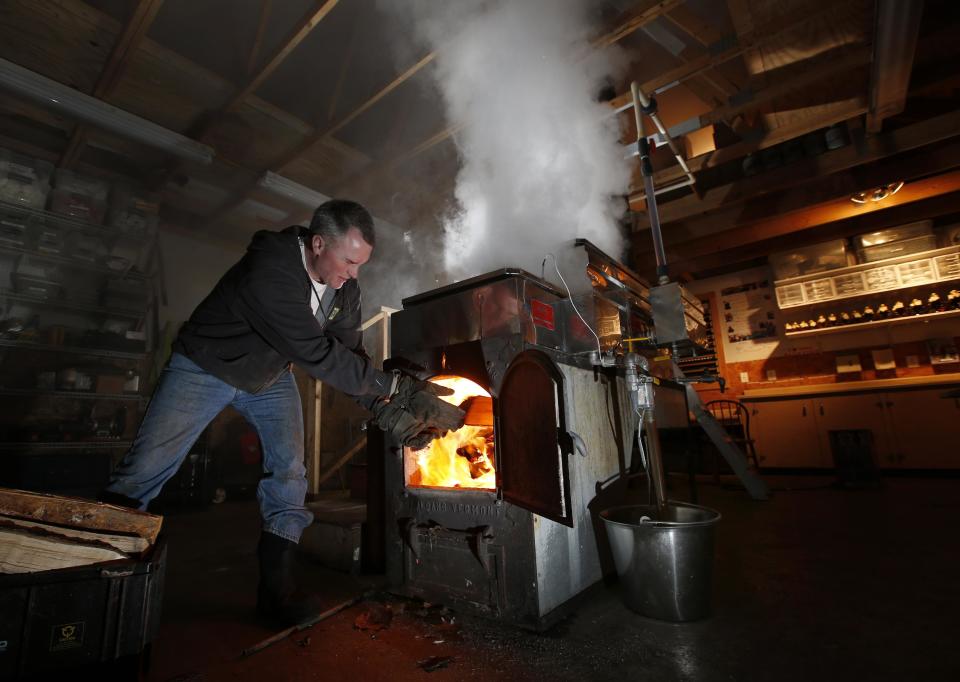 In this March 13, 2014 photo, Paul Boulanger tosses wood in to fire up the sap evaporator at the Turtle Lane Maple sugar house in North Andover, Mass. It takes about 40 gallons of sap to yield one gallon of syrup. Maple syrup season is finally under way in Massachusetts after getting off to a slow start because of unusually cold weather. (AP Photo/Elise Amendola)