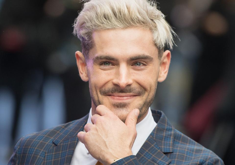 Zac Efron sports a striped two-piece suit with his signature blonde haircut