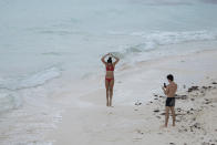 Tourists spend time on the beach in Cancun, Mexico, Saturday, June 13, 2020. An irony of the coronavirus pandemic is that the idyllic beach vacation in Mexico in the brochures really does exist now: the white sand beaches are sparkling clean and empty on the Caribbean coast. (AP Photo/Victor Ruiz)