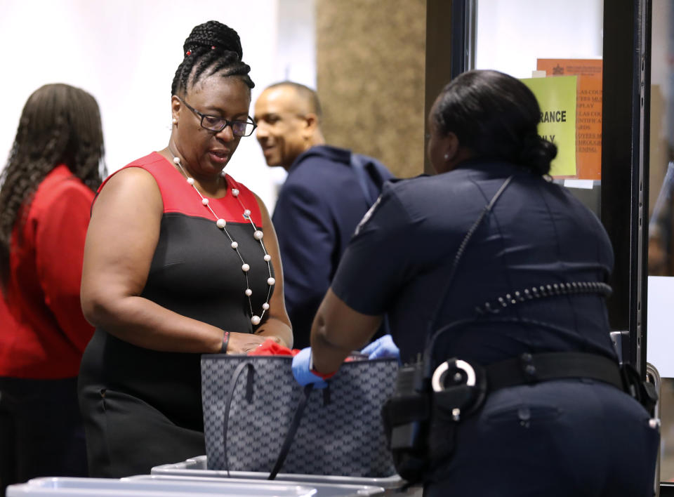 Allison Jean, left, mother of Botham Jean, clears through security as she arrives back at court following a lunch break in the punishment phase in the trial of former Dallas police officer Amber Guyger, Wednesday, Oct. 2, 2019 in Dallas. Guyger, who said she fatally shot her unarmed black neighbor Botham Jean after mistaking his apartment for her own, was found guilty of murder the day before. ((AP Photo/Tony Gutierrez)