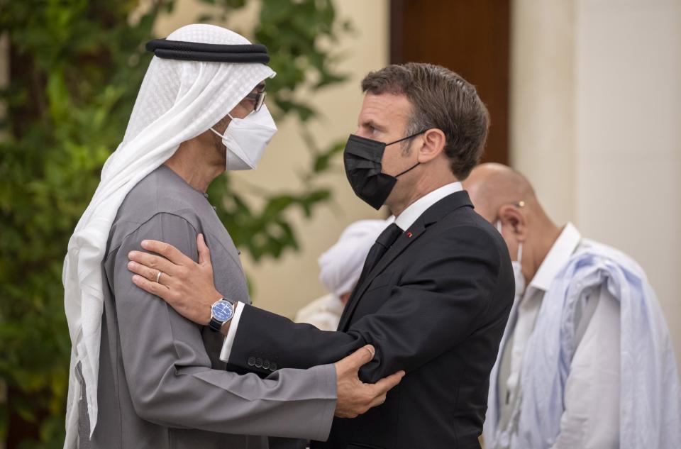 In this photo made available by Ministry of Presidential Affairs, Emmanuel Macron, president of France, right, offers condolences to Sheikh Mohamed bin Zayed Al Nahyan, president of the UAE and ruler of Abu Dhabi, on the passing of Sheikh Khalifa bin Zayed Al Nahyan, late president of the UAE at Mushrif Palace in Abu Dhabi, UAE, Sunday, May 15, 2022. (Abdulla Al Junaibi/Ministry of Presidential Affairs via AP)