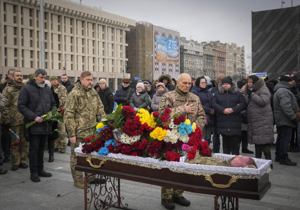 Ukrainian servicemen pay their last respect at the coffin of their comrade Oleh Yurchenko killed in a battlefield with Russian forces in the Donetsk region during a commemoration ceremony in Independence Square in Kyiv, Ukraine, Sunday, Jan. 8, 2023. (AP Photo/Efrem Lukatsky)